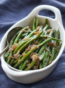 Spoon in a dish of French green beans with shallots.