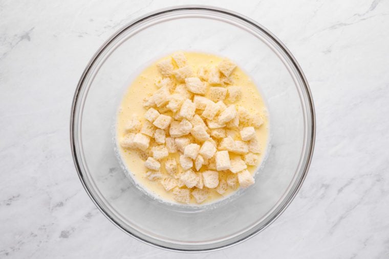 eggs, cream and bread cubes in bowl
