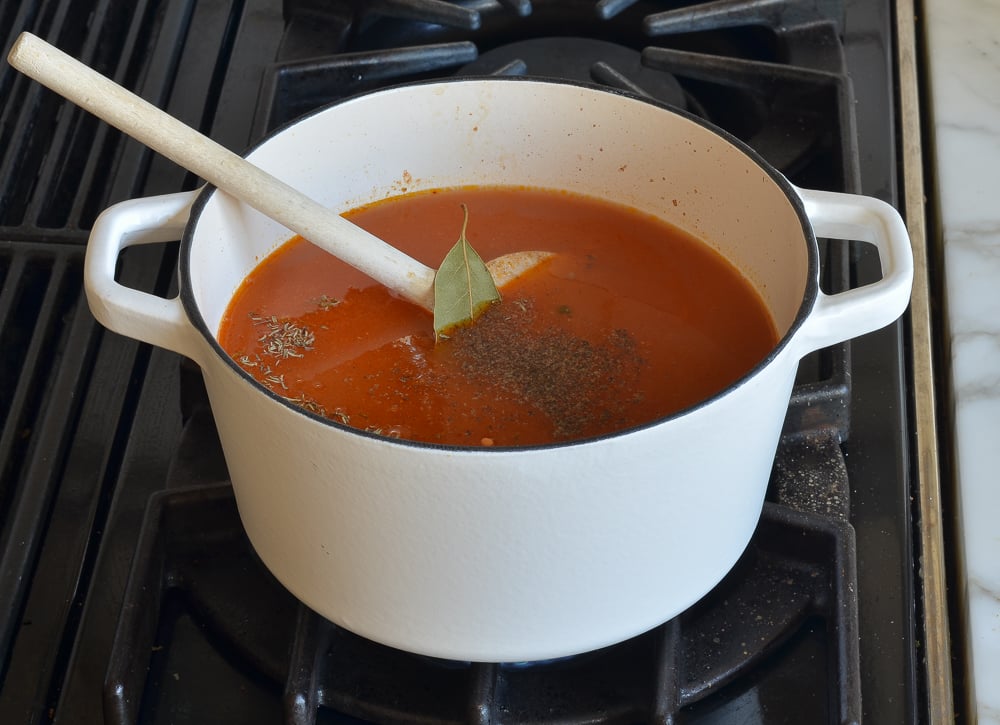 Wooden spoon in a pot with broth and spices.