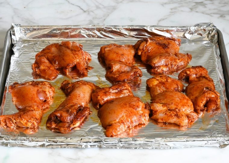 chicken thighs on foil-lined baking sheet