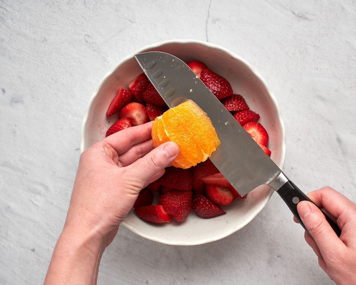 cutting the orange segments out of the oranges