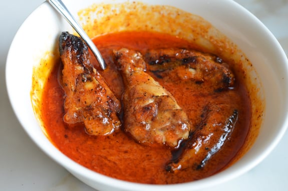 Wings in a bowl of buffalo sauce.