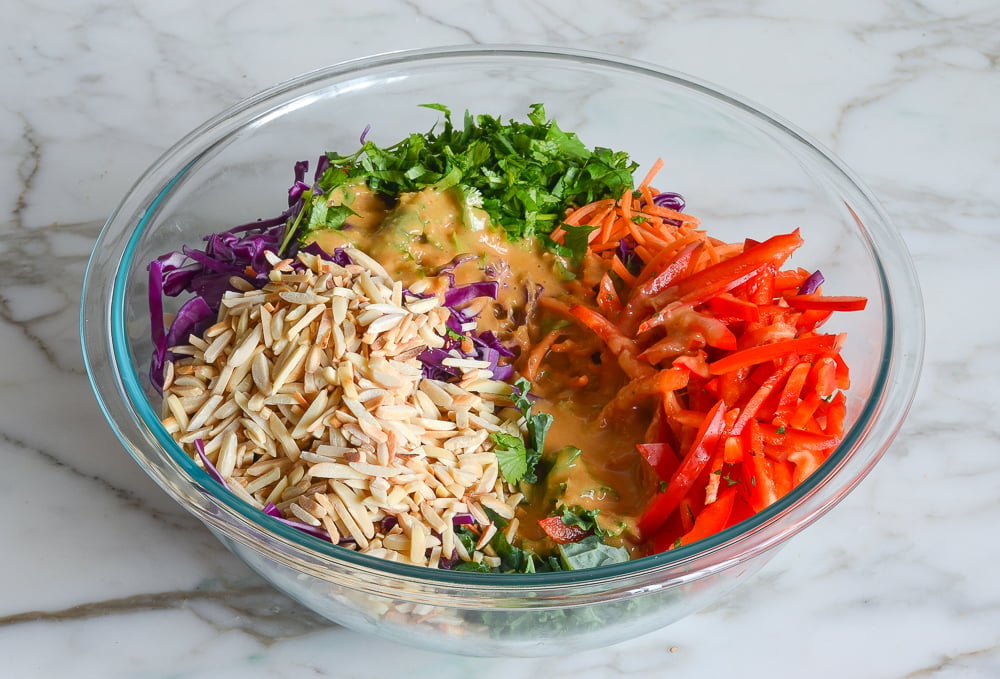 kale salad and dressing in mixing bowl