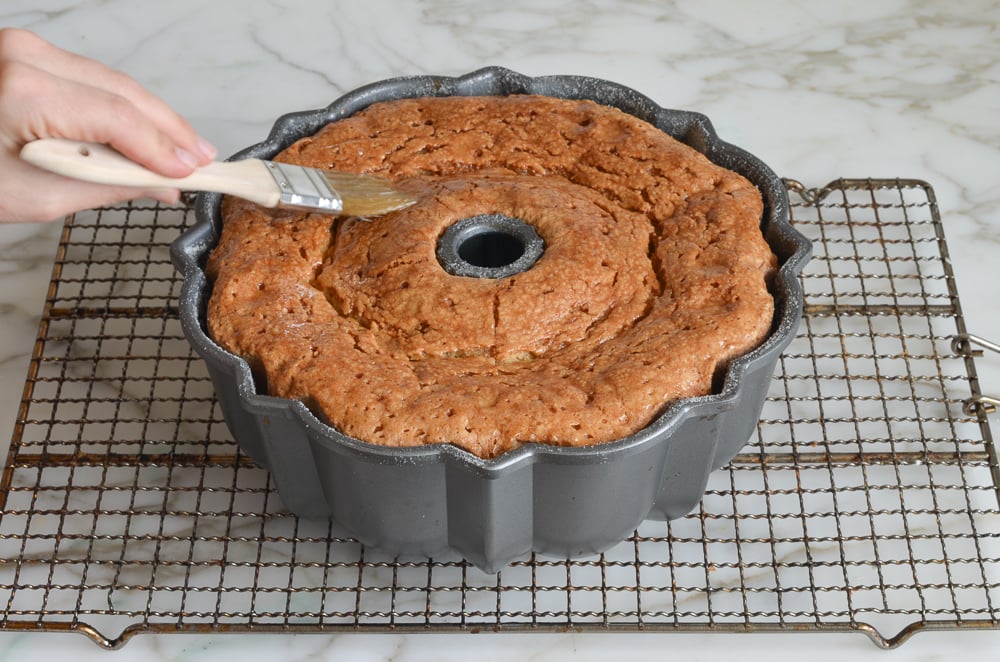 brushing the glaze over the rum cake