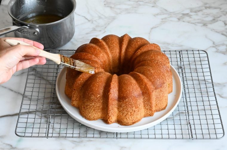 brushing glaze on rum cake