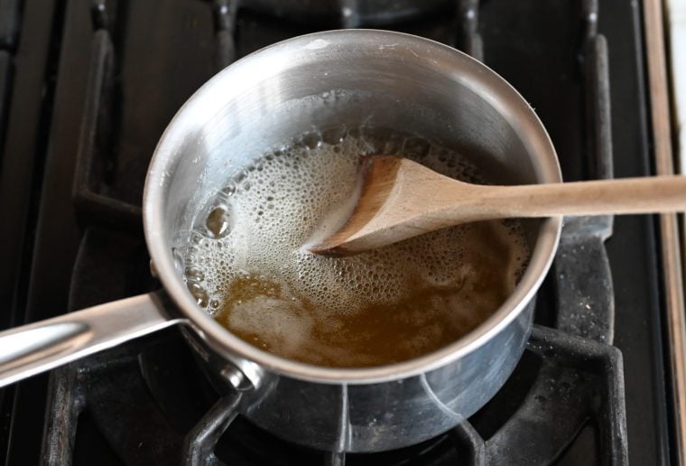 Wooden spoon in a pot with sugar and rum.