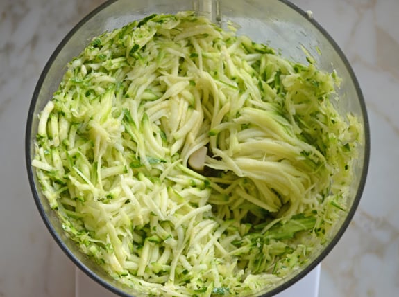 Shredded zucchini in a food processor.