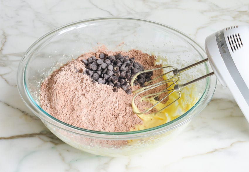 Dry ingredients and chocolate chips added to a bowl with an egg mixture.