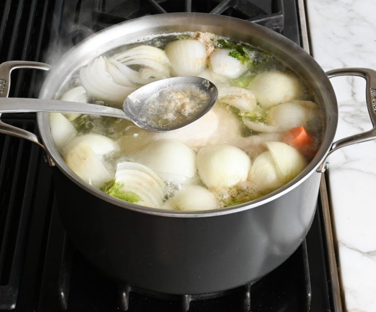 skimming fat from the surface of the soup