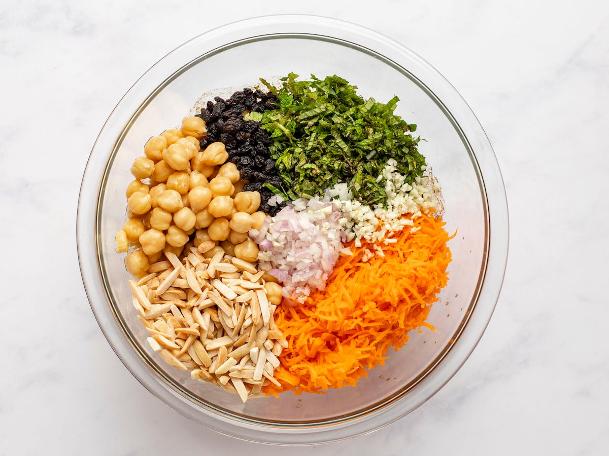 ingredients for moroccan-spiced carrot and chickpea salad in mixing bowl.