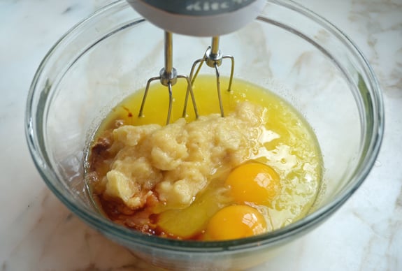 Eggs, bananas, and vanilla in a bowl with a butter mixture.
