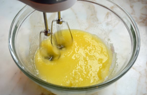 Electric mixer beating butter and sugar.
