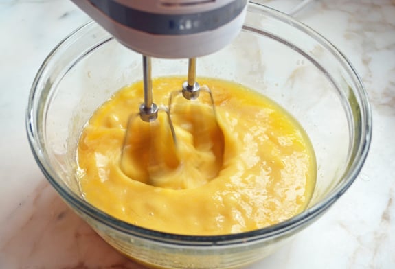 Electric mixer beating a banana mixture.