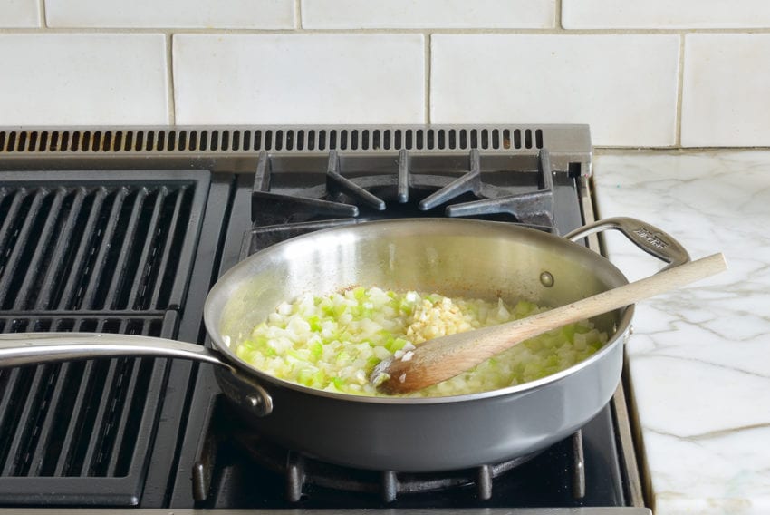 Pile of garlic in a skillet of chopped vegetables.