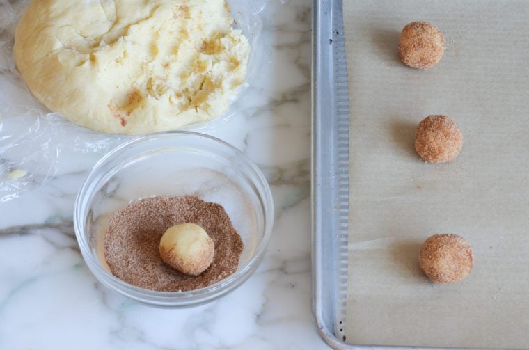 rolling snickerdoodle balls in cinnamon sugar