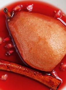 Plate with a baked pear in spiced pomegranate syrup.