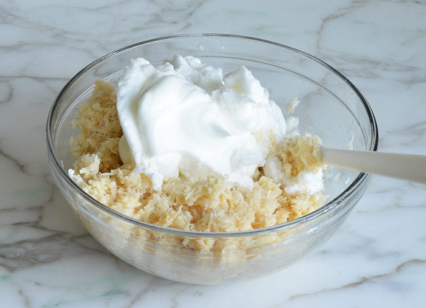 Egg whites in a bowl with a coconut mixture.