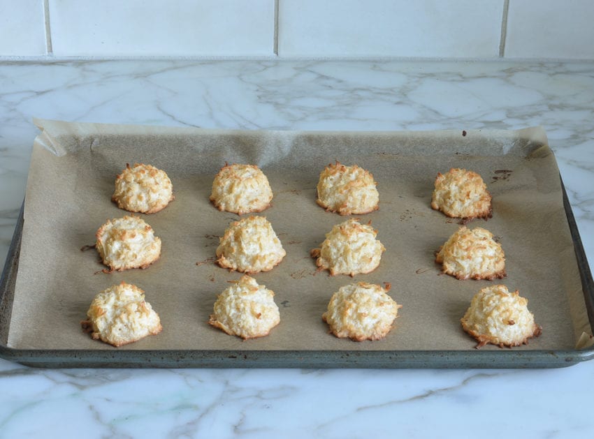 Coconut macaroons on a lined baking sheet.