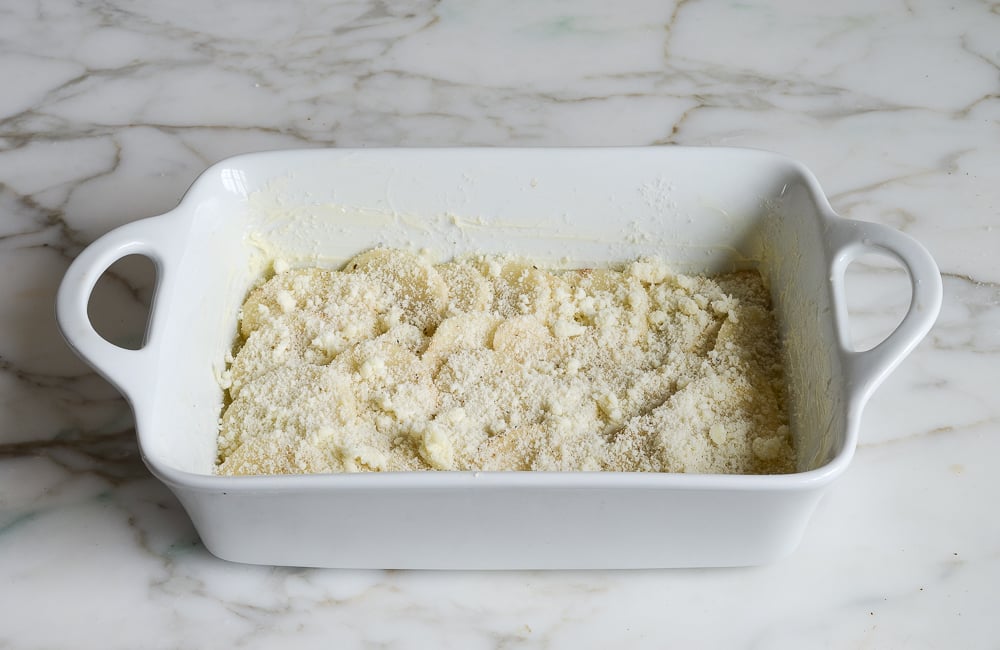 sprinkling the cheese over the potatoes