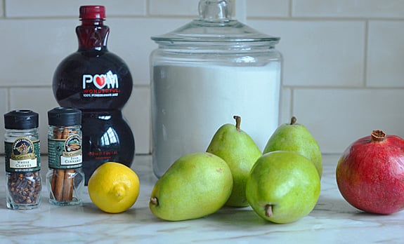 Baked pear ingredients including lemon, cloves, and Pom.