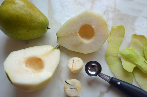 Cored and peeled pears on a counter.