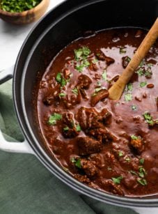 Wooden spoon in a pot of chili con carne.