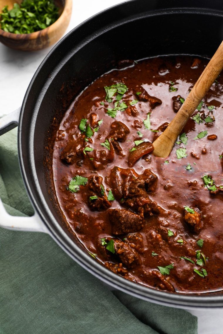Wooden spoon in a pot of chili con carne.