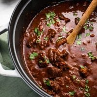 Wooden spoon in a pot of chili con carne.