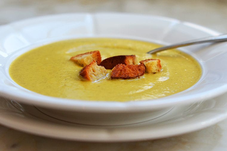 Bowl of broccoli soup topped with croutons.