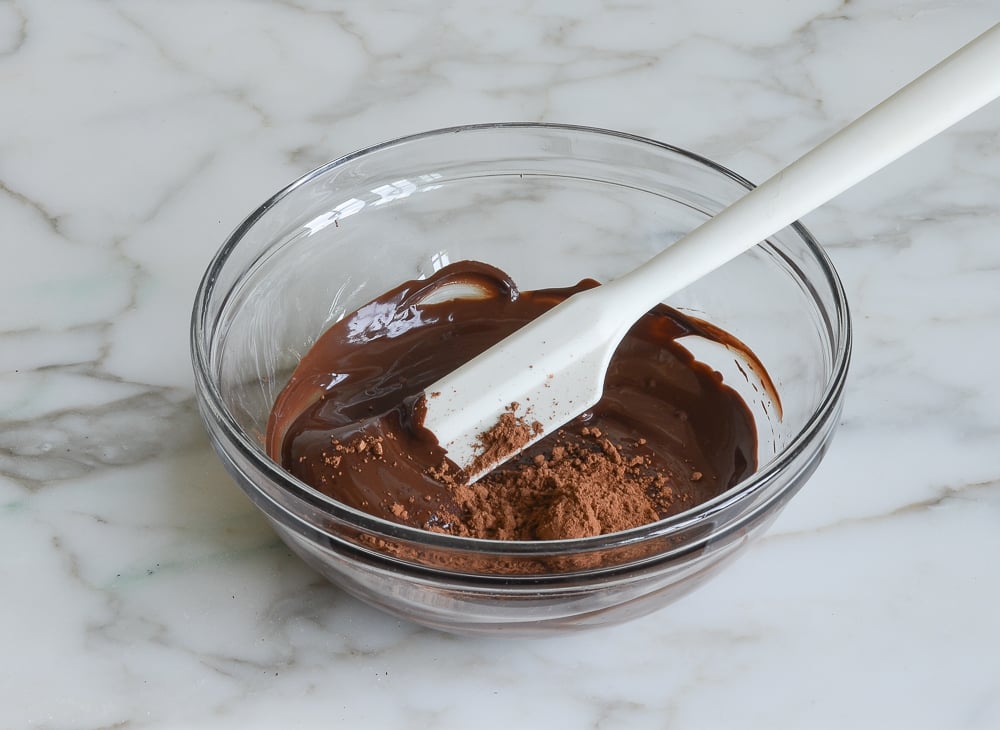 adding cocoa powder to melted chocolate