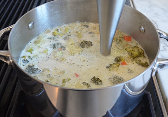 Immersion blender in a pan of soup.