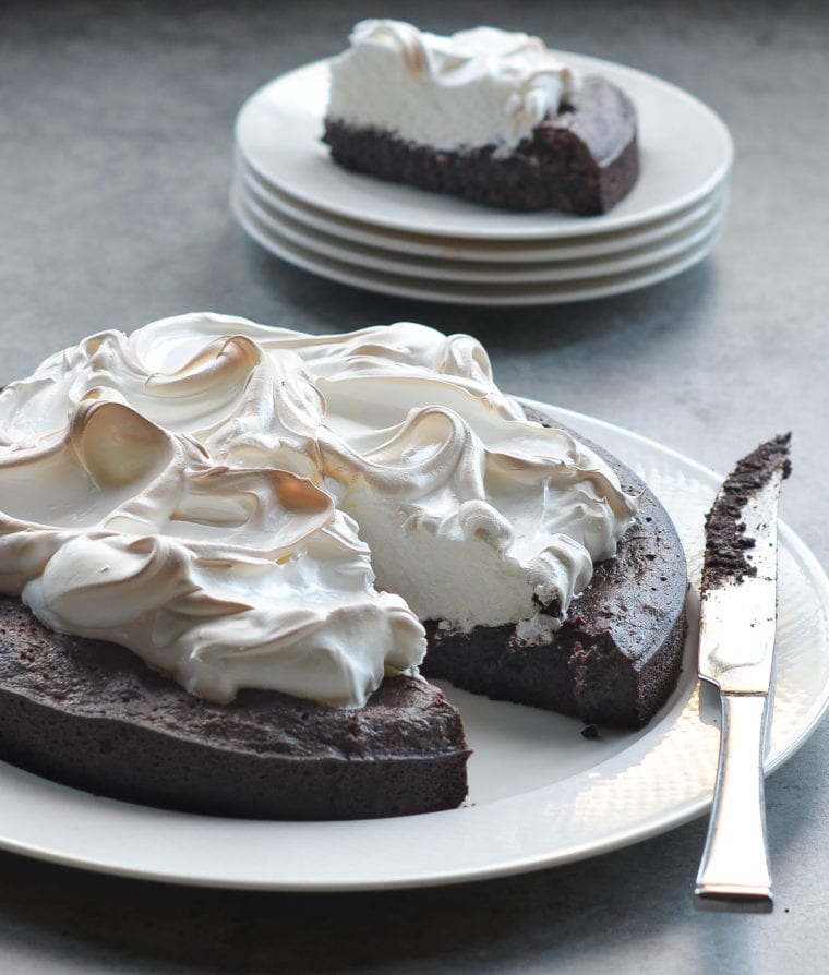 Flourless chocolate cake with meringue missing a slice.