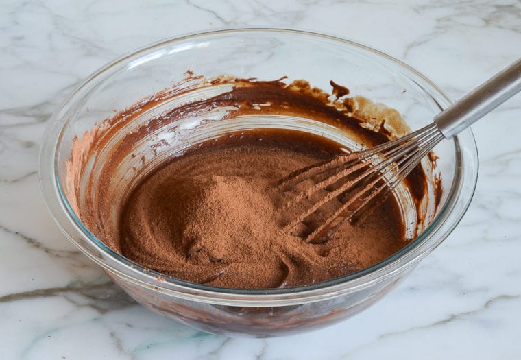 adding the sifted cocoa powder to the cake batter