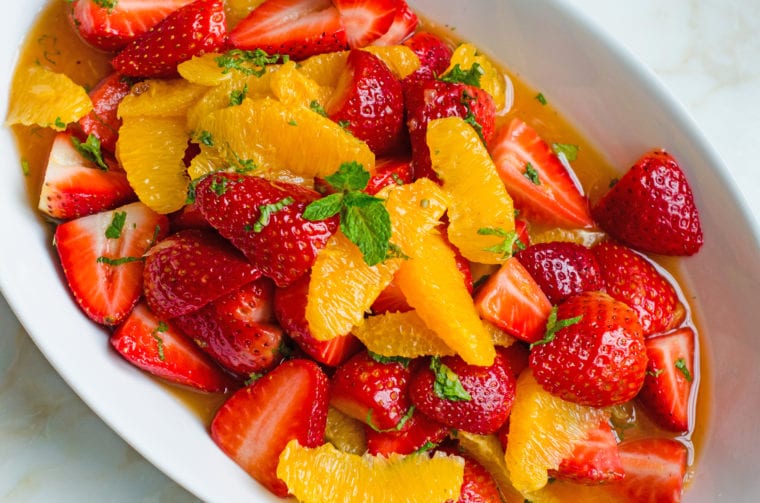 Dish of strawberry orange salad with syrup.