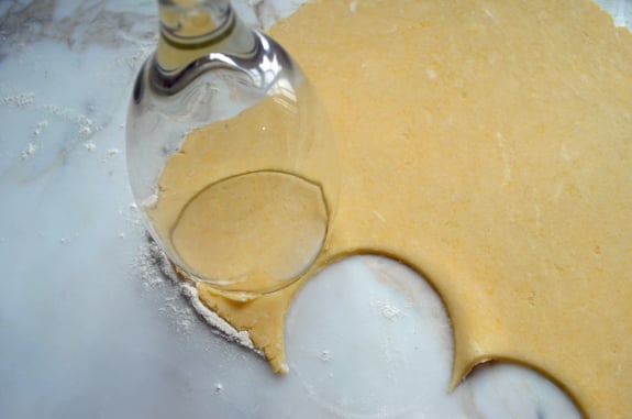 Wine glass cutting circles out of dough.