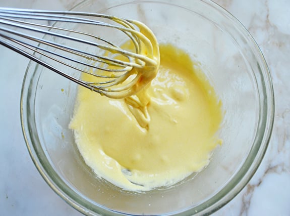 Pale yellow ribbons of batter falling from a whisk.