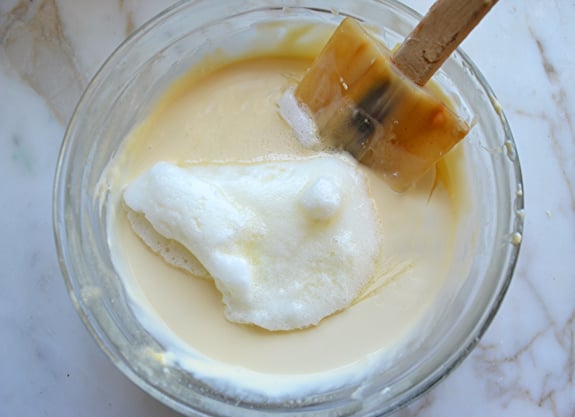 Whisked egg whites in a bowl with batter.
