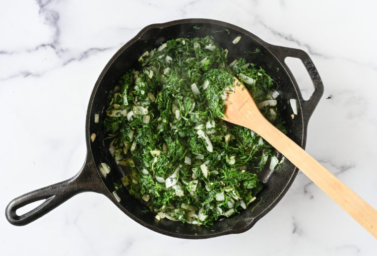 cooking the spinach and garlic with the onions