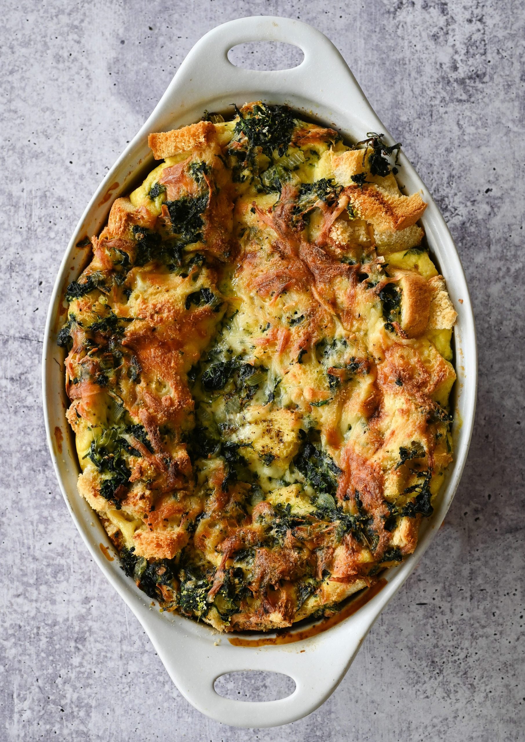 Spinach and cheese strata in a baking dish.