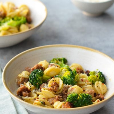 Bowls of orecchiette with sausage and broccoli.