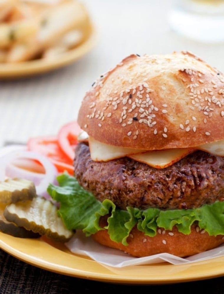 Steakhouse burger on a plate with toppings.