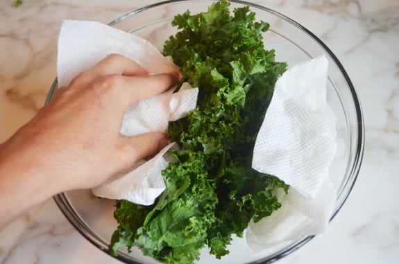 Person using paper towels to dry kale.