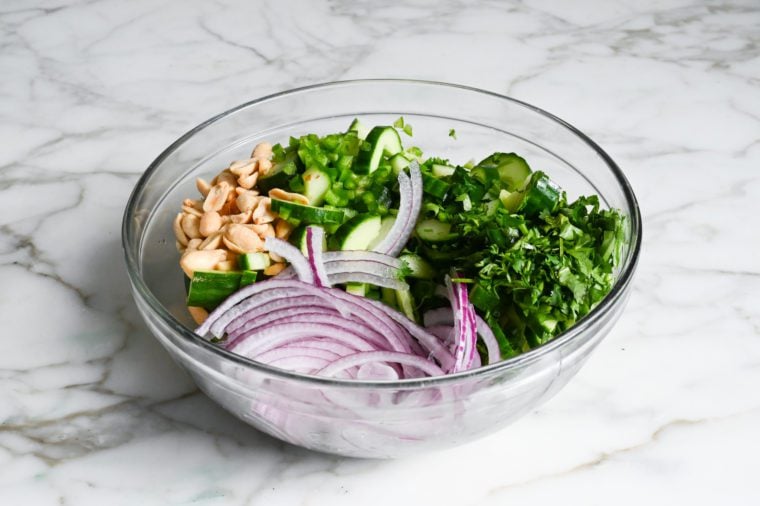 Thai cucumber salad ingredients added to dressing