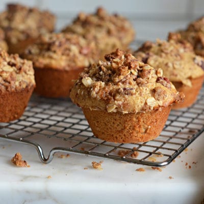 Oat muffins with pecan streusel topping on a wire rack.