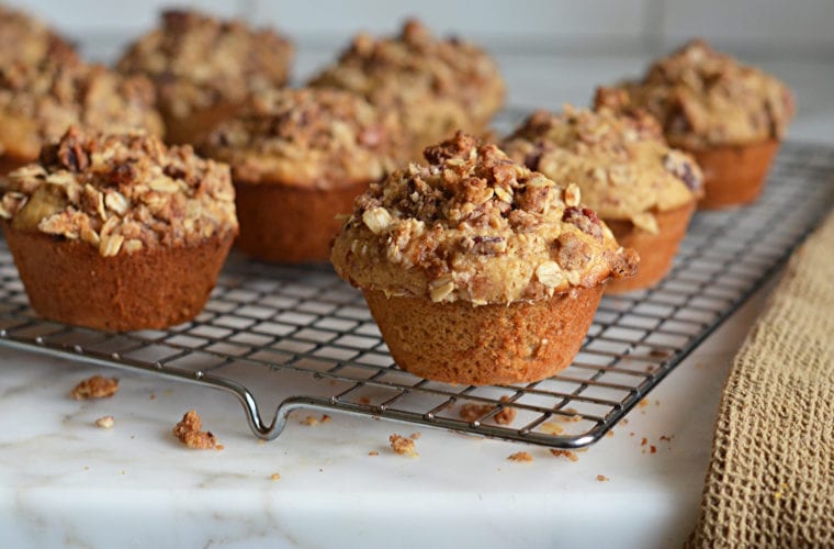 Oat muffins with pecan streusel topping on a wire rack.