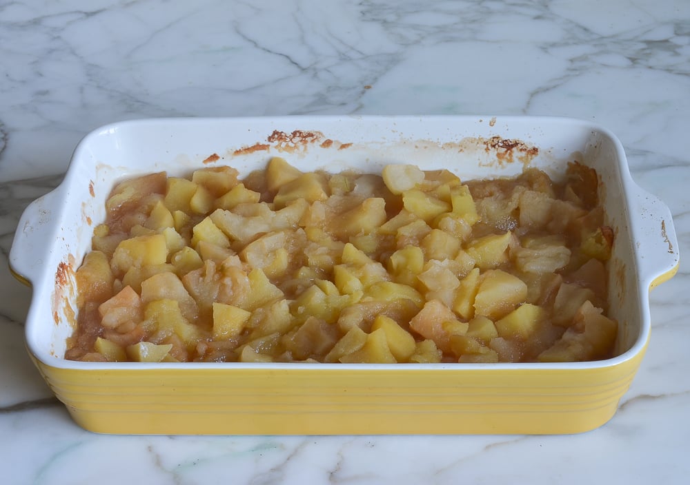Cooked, seasoned apples in a yellow baking dish.