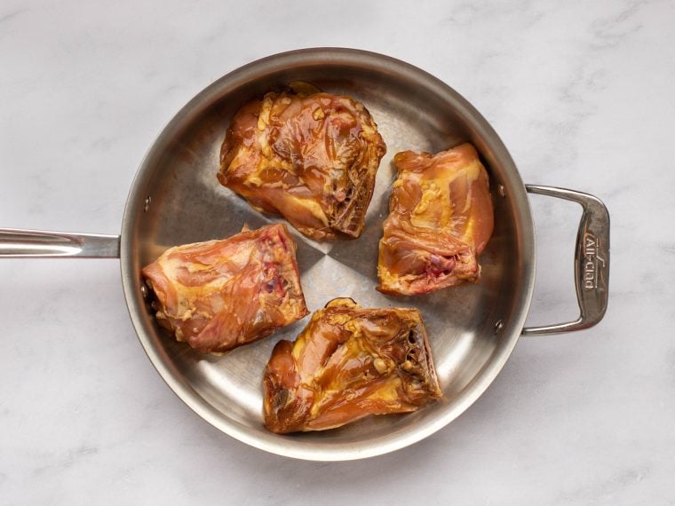 searing the chicken in a skillet