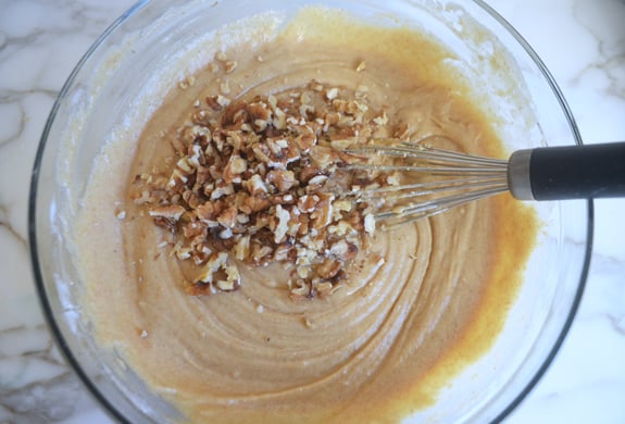 Nuts in a bowl with muffin batter.