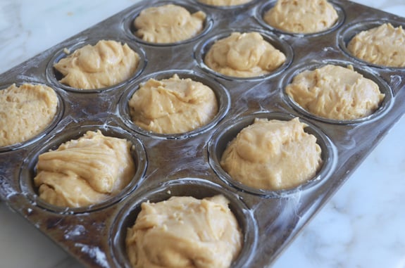 Muffin tin full of maple muffin batter.