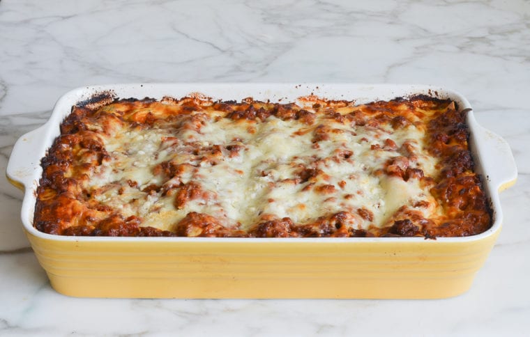 Yellow baking dish of baked lasagna.